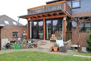 a house with large glass windows and a patio at Fewo Am Kendel in Kruft