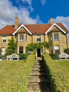 una gran casa de ladrillo con un camino que conduce a ella en Lodge Farm Bed & Breakfast, en Hitchin