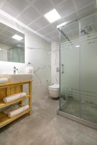 チェシメにあるTwins Hotel Çeşmeのバスルーム(ガラス張りのシャワー、シンク付)