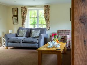 a living room with a blue couch and a coffee table at Emma Dent in Winchcombe