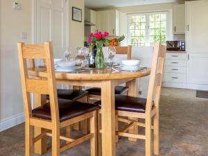 a kitchen with a wooden table with chairs and wine glasses at Emma Dent in Winchcombe