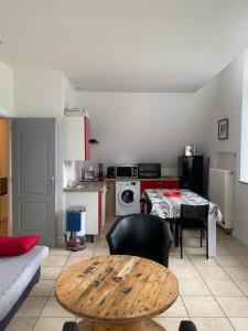 a living room with a table and a kitchen at La bourboule Appartement in La Bourboule