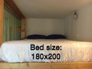 a bed in a bedroom with a bed sign on it at The fruit garden guesthouse in Kfar Yona