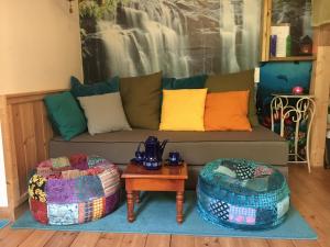 a living room with a couch and two ottomans at The fruit garden guesthouse in Kfar Yona