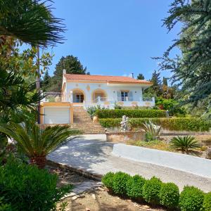 a white house with a gate and a driveway at Villa Southern Comfort in Lefkímmi