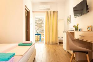 a small living room with a bed and a television at sofia's cozy rooms in Himare
