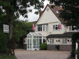 a house with two british flags on top of it at Royal Square Hotel - NEC & Birmingham Airport in Marston Green