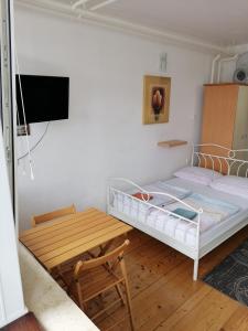Schlafzimmer mit einem Bett und einem Holztisch in der Unterkunft Peter rooms in Ljubljana