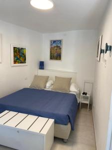 a bedroom with a bed with a blue comforter at Camere Nicolina 4 in Vernazza