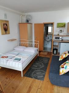 a bedroom with a white bed and a kitchen at Peter rooms in Ljubljana