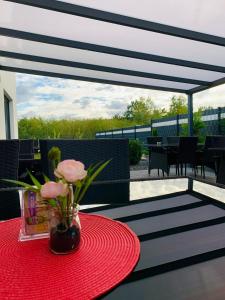 a red table with a vase of flowers on a patio at Hotel Restaurant Ayhan in Burgdorf