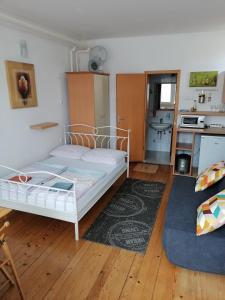 1 Schlafzimmer mit einem weißen Bett und einer Küche in der Unterkunft Peter rooms in Ljubljana