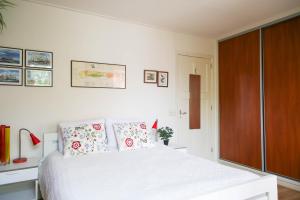 een slaapkamer met een wit bed met kussens erop bij Logement het Herenwaltje in Leeuwarden