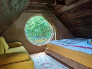 - une chambre avec un lit et une fenêtre ovale dans l'établissement Ptasia Osada, à Gardna Wielka