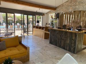 a living room with a couch and a kitchen at Le Mas de Cocagne in Saintes-Maries-de-la-Mer
