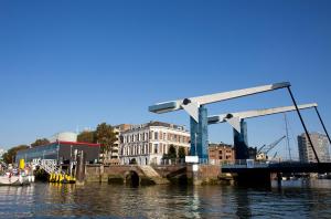 eine Brücke über einen Wasserkörper mit Gebäuden in der Unterkunft Suitehotel Pincoffs in Rotterdam