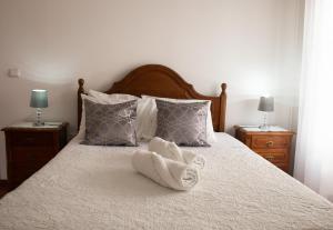 a bedroom with a bed with two towels on it at Gouveia Residence in Coimbra