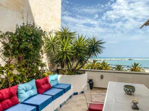 a couch on a balcony with a view of the ocean at Terrazza Diomede- Manfredi Homes & Villas in Manfredonia