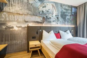 a hotel room with a bed and a mural at Seebrunn - Kuppelwieser Alm in Ultimo