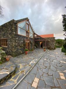 een stenen loopbrug naar een stenen huis bij Casa Rural Casa & Monte in Casas del Monte