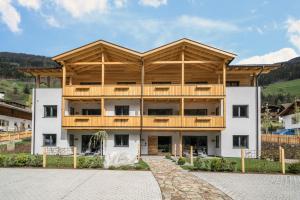 a large white building with a wooden roof at Seebrunn - Außere Schwemmalm in Ultimo