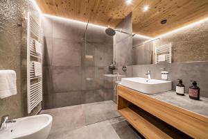 a bathroom with a sink and a toilet and a mirror at Seebrunn - Außere Schwemmalm in Ultimo