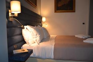 a hotel room with a bed with a lamp and a book at Sweet Home Parioli in Rome