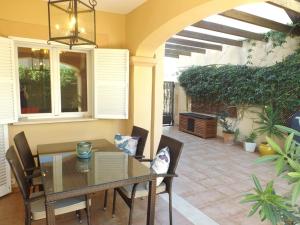 einen Essbereich mit einem Tisch und Stühlen sowie eine Terrasse in der Unterkunft Ferienhaus Casa Yelmo in Cala Mendia