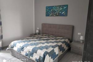 ein Schlafzimmer mit einem Bett mit einer blau-weißen Decke in der Unterkunft Home sweet home appartamento ricco di comfort in Palermo