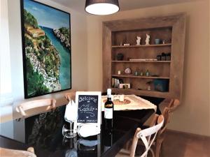 uma sala de jantar com uma mesa e uma garrafa de vinho em Apartment En Capillo em Manacor