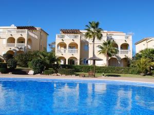 a large house and a swimming pool in front of a building at Apartment En Capillo in Manacor