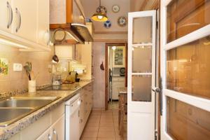 una cocina con armarios blancos y fregadero en Hauzify I Casa Colonial, en Sant Pol de Mar