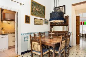 a kitchen and dining room with a wooden table and chairs at Hauzify I Casa Colonial in San Pol de Mar