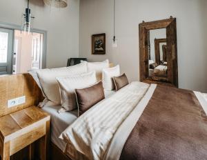 una camera con un grande letto e uno specchio di Boutique hotel Corso a Řevnice