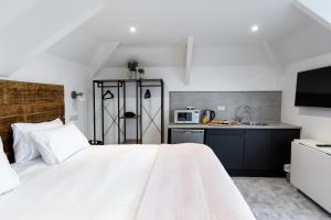 a bedroom with a white bed and a kitchen at Park View in Falmouth