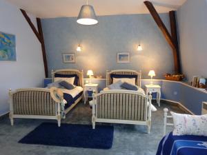 a bedroom with three wicker beds and two tables at La Maison Ribotteau in LʼIsle-Jourdain +52 photos