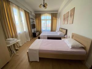 a hotel room with two beds and a window at HC Hotel & Suites in Vlorë