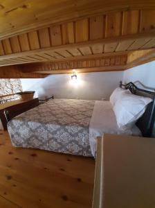 a bedroom with a bed in a room with wooden floors at Casa Nikolou Halki in Halki +3 photos