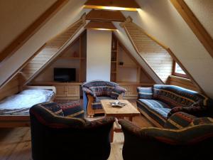 a attic living room with two couches and a bed at Apartmány SKI Čertovica in Liptovská Sielnica