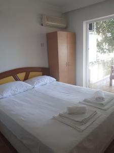 a white bed with two towels on top of it at MARTILI VİLLA LARA ANTALYA in Antalya