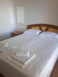 a white bed with two towels on top of it at MARTILI VİLLA LARA ANTALYA in Antalya