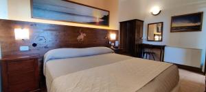 a bedroom with a bed and a wooden wall at Locanda Mossa Dei Barbari in Buriano