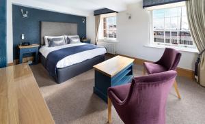 a hotel room with a bed and two chairs at Ennios Boutique Hotel in Southampton