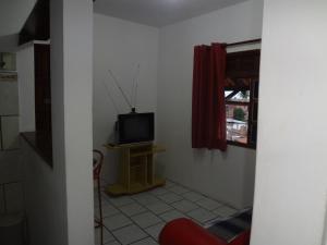 Habitación con TV en una mesa y una ventana en Condomínio Mar Azul en Salvador