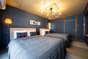 1 dormitorio con 2 camas y ventilador de techo en Oyado Urushi / Vacation STAY 50682 en Nagasaki