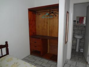 y baño con armario de madera y lavabo. en Condomínio Mar Azul en Salvador