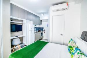 Cette chambre blanche dispose d'un lit et d'une cuisine. dans l'établissement 360 Luz, à São Paulo