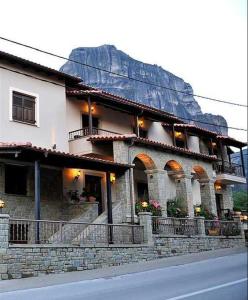 een gebouw aan de kant van een straat met een berg bij Guesthouse Vavitsas in Kalabaka