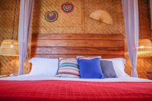 uma cama com cabeceira em madeira e almofadas em Pousada TeMoana em Ubatuba