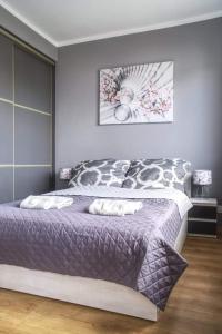 um quarto com uma cama com um edredão roxo em M&S Apartament em Świnoujście